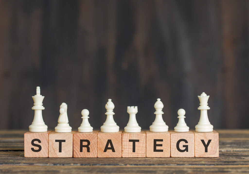 Business strategy concept with chess pieces on wooden cubes on wooden background side view.